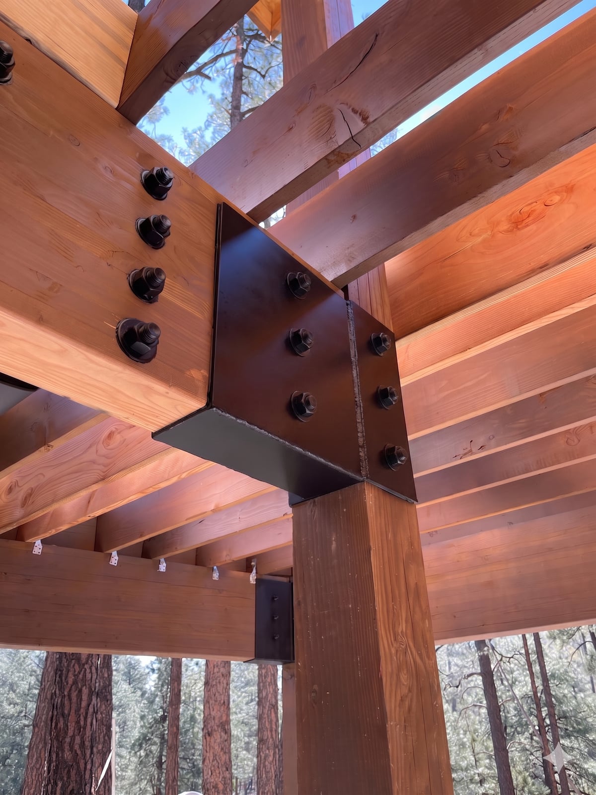 Custom welded steel bracket fabricated to fit a timber-framed log cabin in Prescott