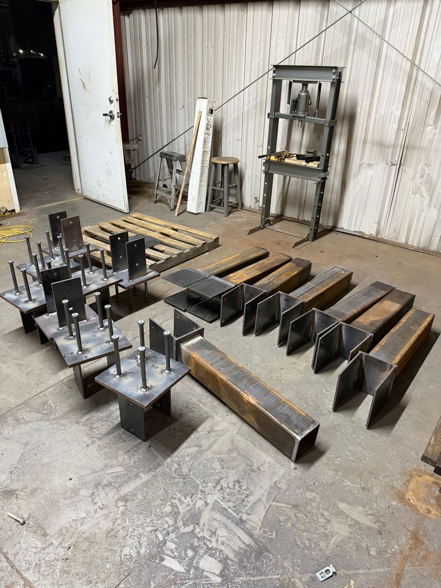 Shop-welded column bases and weldments with anchor bolts, fabricated for an engineered steel package