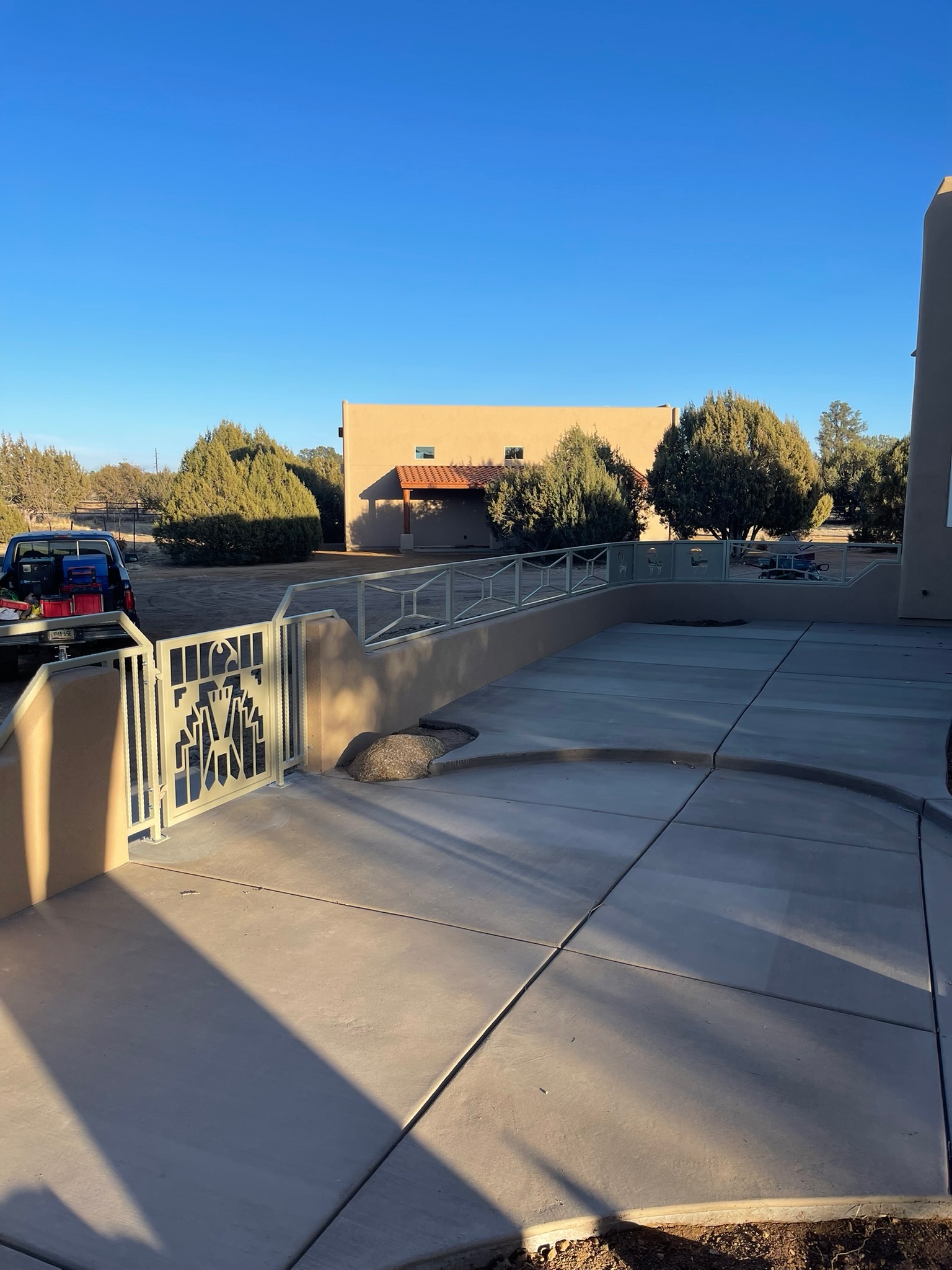 Custom railing with animal figure panels and a thunderbird gate along a residence entry