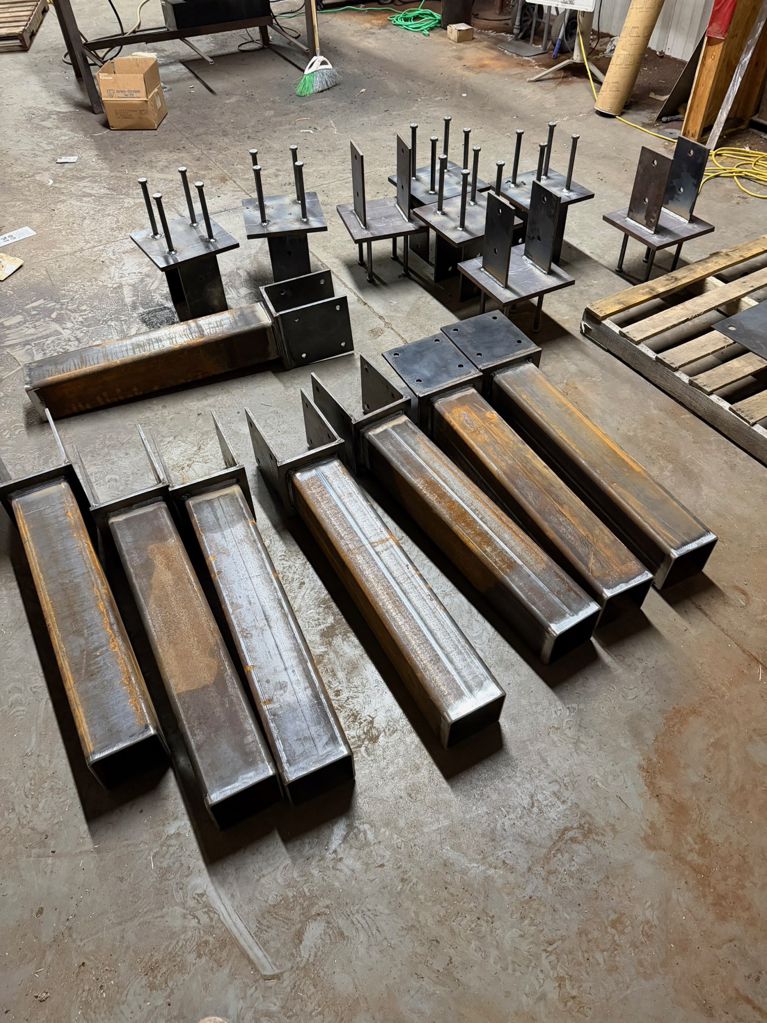 Shop-fabricated columns, base plates, and brackets laid out for delivery